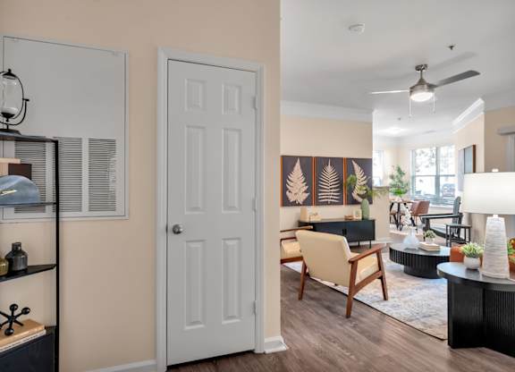 A living room with a white door and a wooden chair.