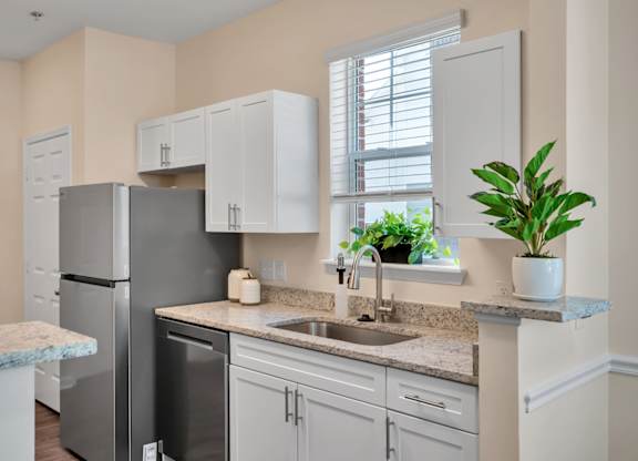 A kitchen with a granite countertop and white cabinets.