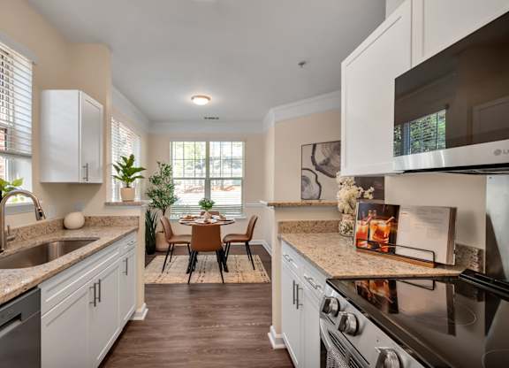 A kitchen with a black stove top oven and a sink with a faucet.