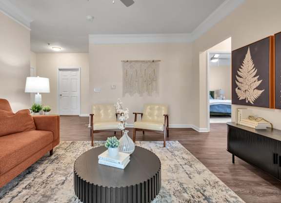 A living room with a brown sofa, a coffee table, and a rug.