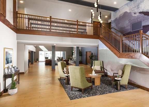 A large room with a staircase and a mural on the wall.