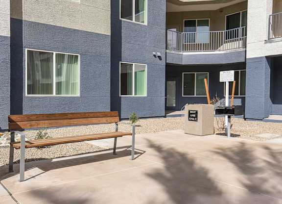 A bench sits in front of a building with a sign that says "The Park".