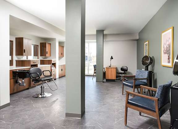 A living room with a blue chair and a black speaker.