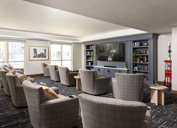 A room with grey chairs and a television.