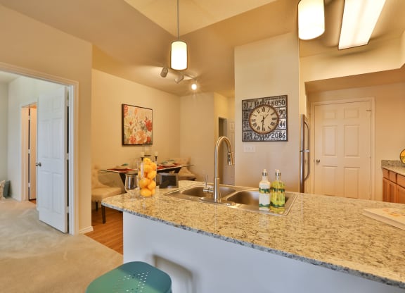a kitchen with a granite counter top and a sink at Cedars of Elk Drive 55+ Apartments, Burleson, TX