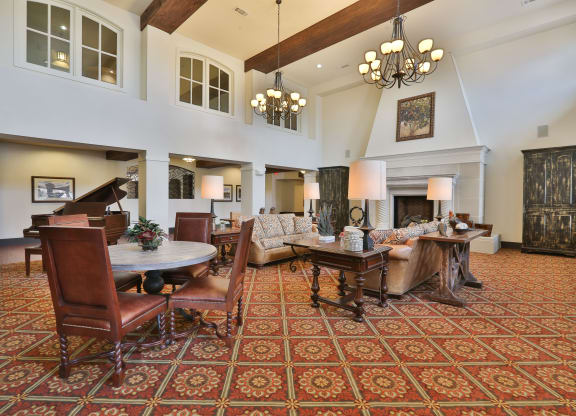 a large living room with furniture and a piano at Cedars of Elk Drive 55+ Apartments, Burleson, TX 76028