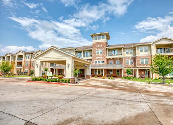 an apartment building with an empty parking lot at Mariposa at South Broadway, TX 76058