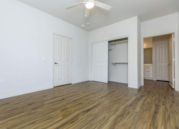 an empty living room with white walls and a ceiling fan at Mariposa at Westchester, Texas