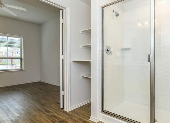 a walk in shower with a glass door in a bathroom at Mariposa at Westchester, Texas, 75052