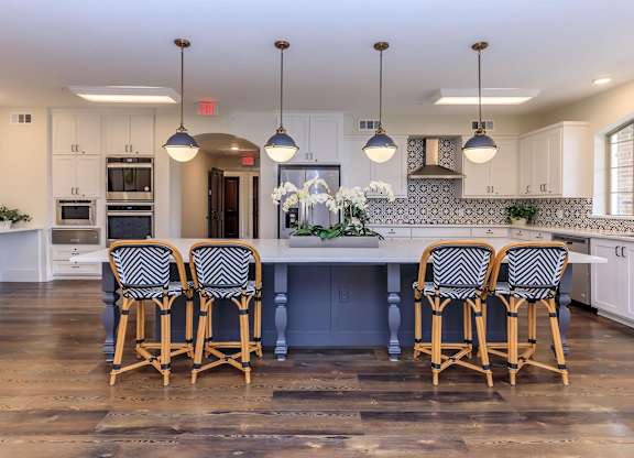 a large kitchen with a large island and chairs at Mariposa at Westchester, Texas