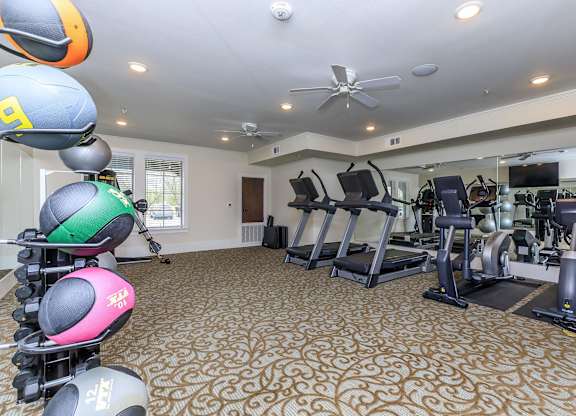 a gym with treadmills and other exercise equipment at Mariposa at Westchester, Grand Prairie Texas