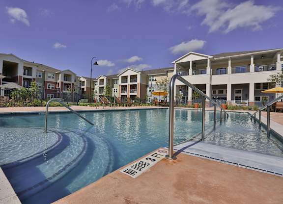 a swimming pool with apartments in the background