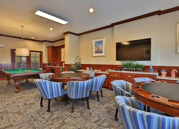a billiards room with tables and chairs and a television