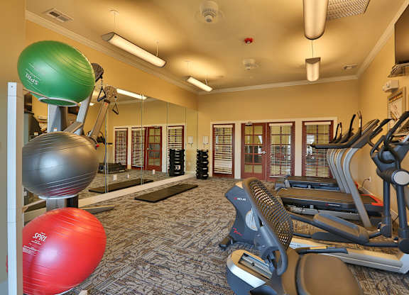 a gym with cardio equipment and weights at the enclave at university heights