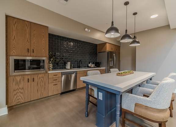 A kitchen with a table and chairs.