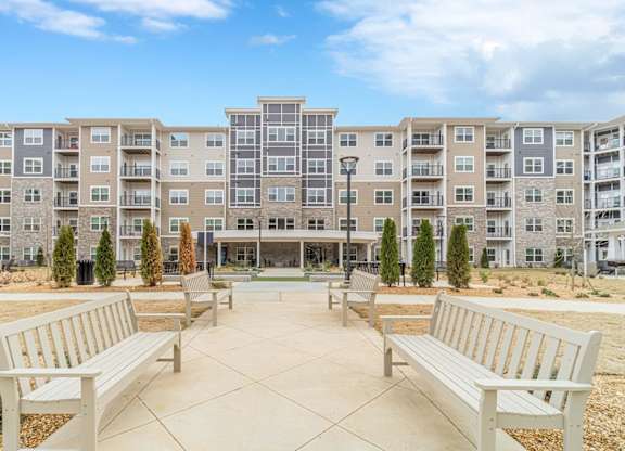 A large apartment complex with a central courtyard and benches.