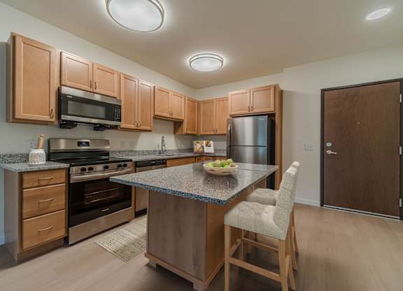 A kitchen with wooden cabinets and granite countertops.