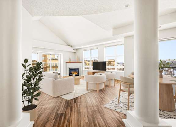 A living room with white furniture and a wooden floor.