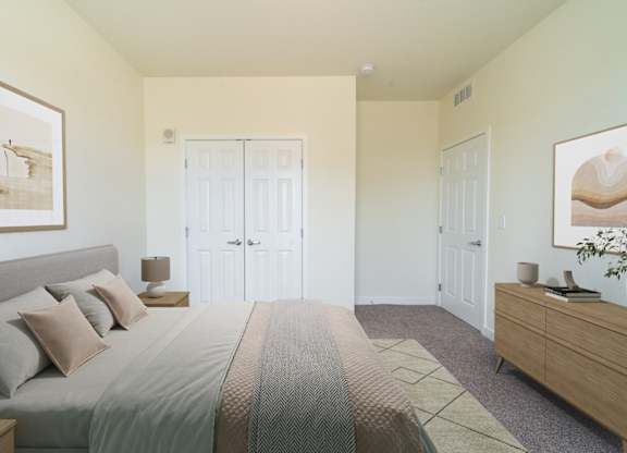 A bedroom with a bed, nightstand, and two doors.