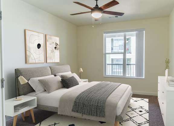 A bedroom with a bed, nightstand, and a ceiling fan.