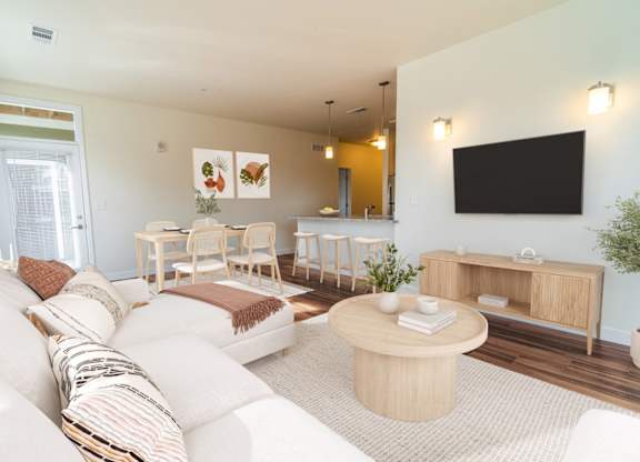 A living room with a white couch and a wooden coffee table.
