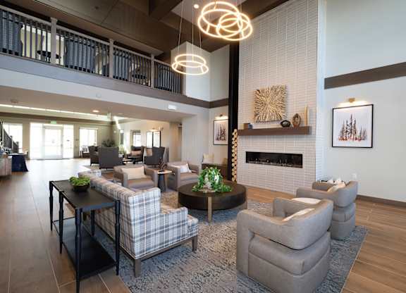 A modern living room with a fireplace and a large grey sofa.