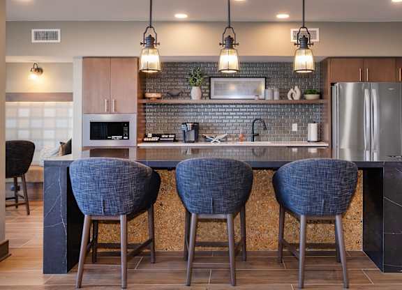 A kitchen with a bar area featuring a counter and chairs.