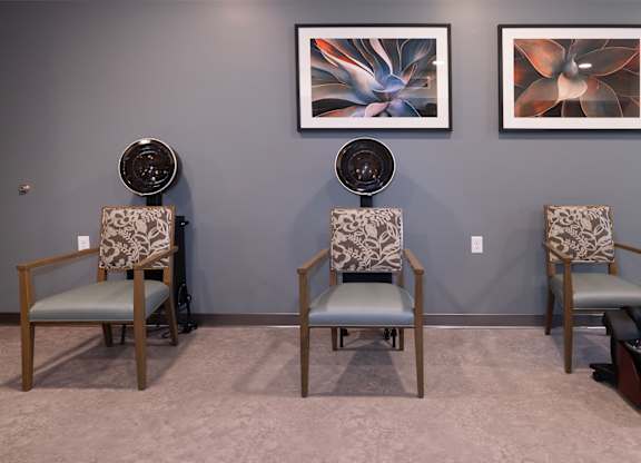 Three chairs with patterned cushions are arranged in a row.