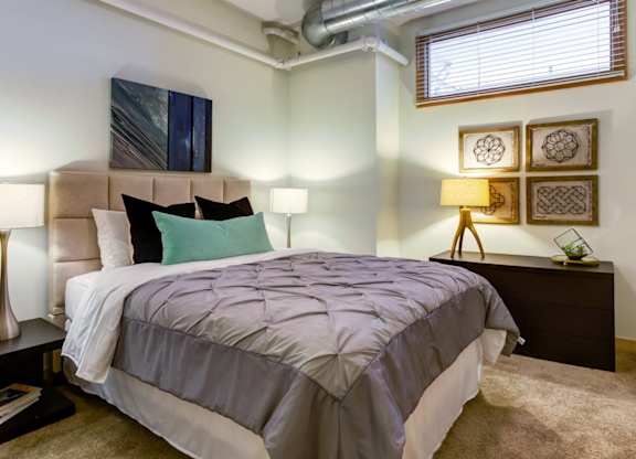 Bedroom with large bed and nightstand at Arcade Apartments, St Louis, 63101