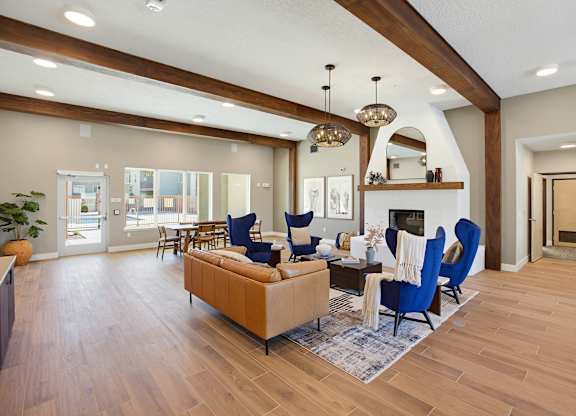A living room with a fireplace and blue chairs.