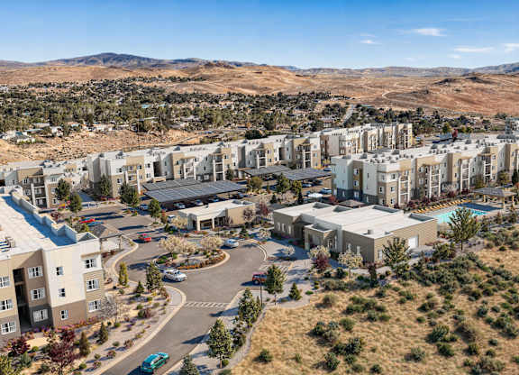 A large residential complex with a swimming pool and a parking lot.