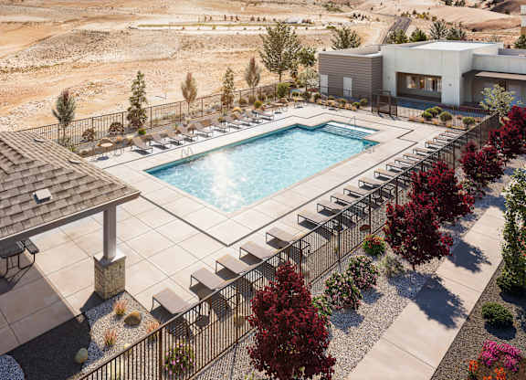 A pool surrounded by trees and a building in the background.