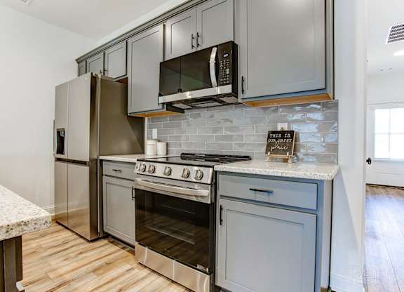 A kitchen with a stove top oven and microwave.