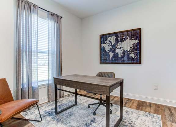 an office space with a desk and chair and a window