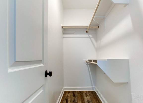 A white door with a black handle is on the left and a white wall with a skylight is on the right.