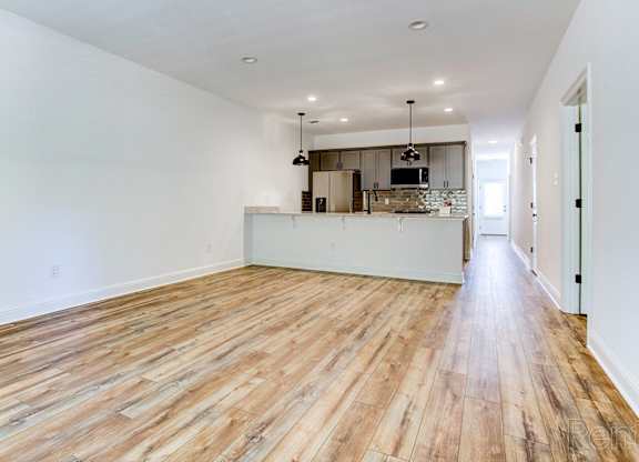 the living room and kitchen of a new home with wood flooring