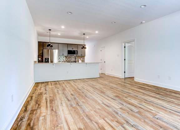 the living room and kitchen of a new home with wood flooring