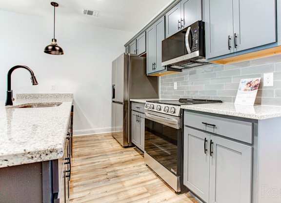 a modern kitchen with stainless steel appliances and white cabinets