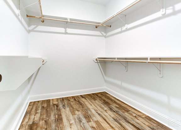 an empty room with white walls and wooden floors and a white closet