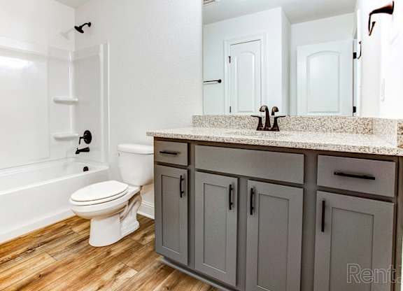 a bathroom with gray cabinets and a toilet and a sink