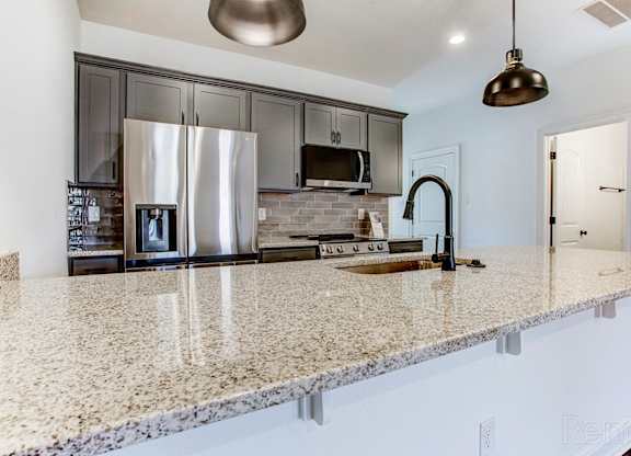 a kitchen with granite counter tops and stainless steel appliances
