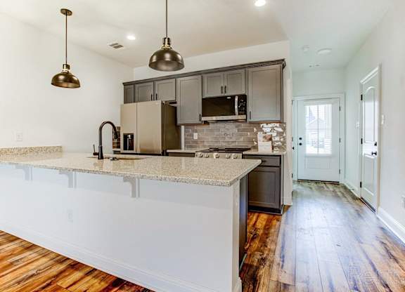 an empty kitchen with a counter top and a sink