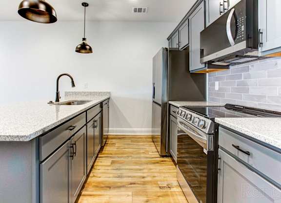 a kitchen with stainless steel appliances and white counter tops