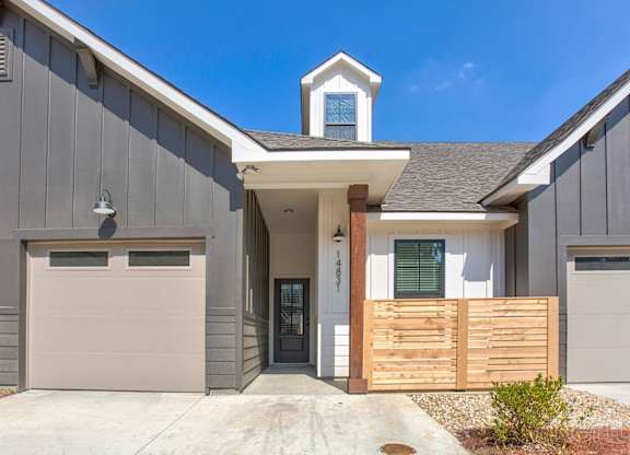 the front of a house with two garage doors