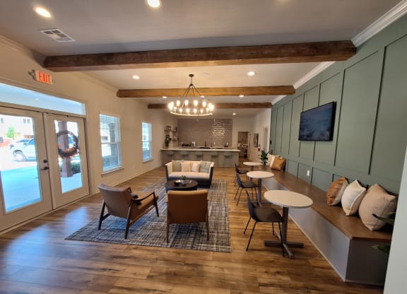 a large living room with chairs and tables and a kitchen