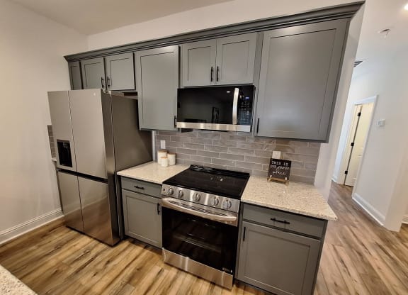 a kitchen with stainless steel appliances and gray cabinets