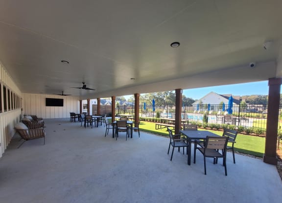 a large patio with tables and chairs and a view of a playground