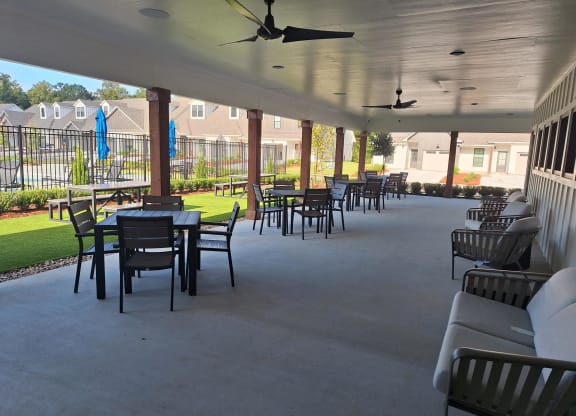 a patio with tables and chairs and a porch