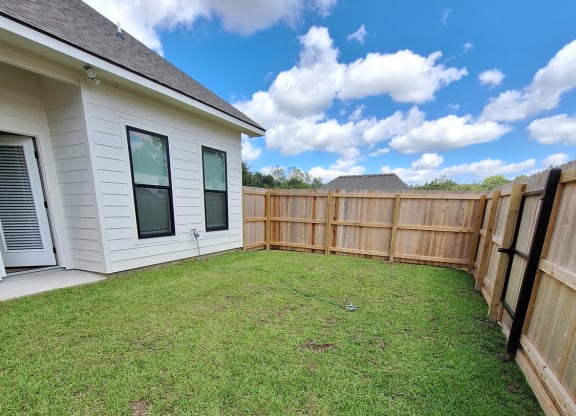 a backyard with a fence and a house