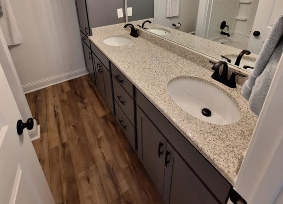 a bathroom with a sink and a mirror and a wood wall